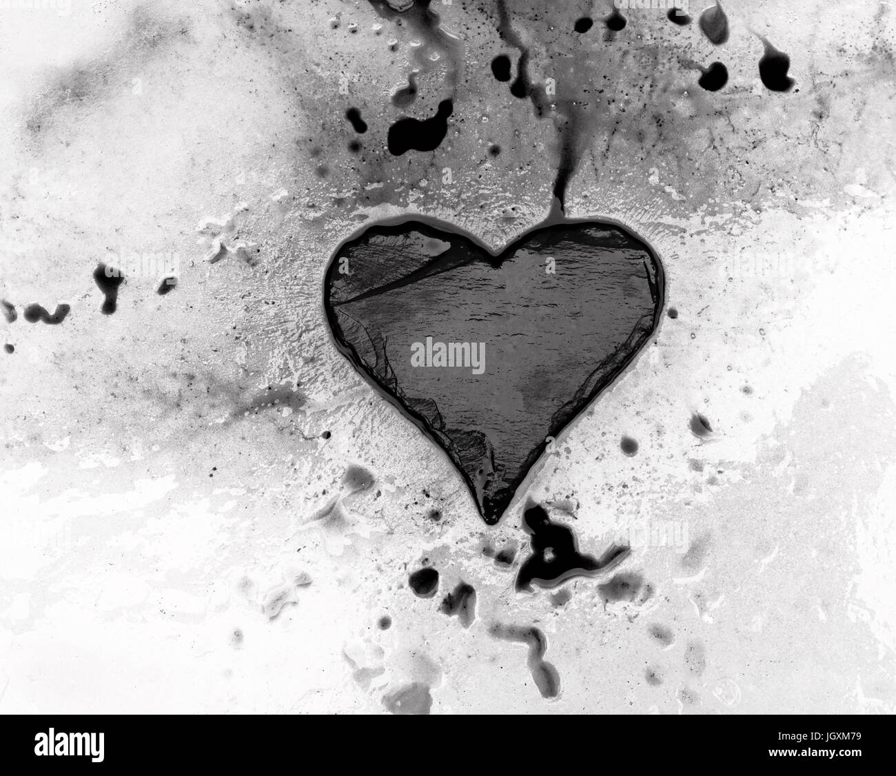 Corazón de pizarra sobre hielo derritiéndose con tinta extendiendo hacia los huecos en la superficie Foto de stock