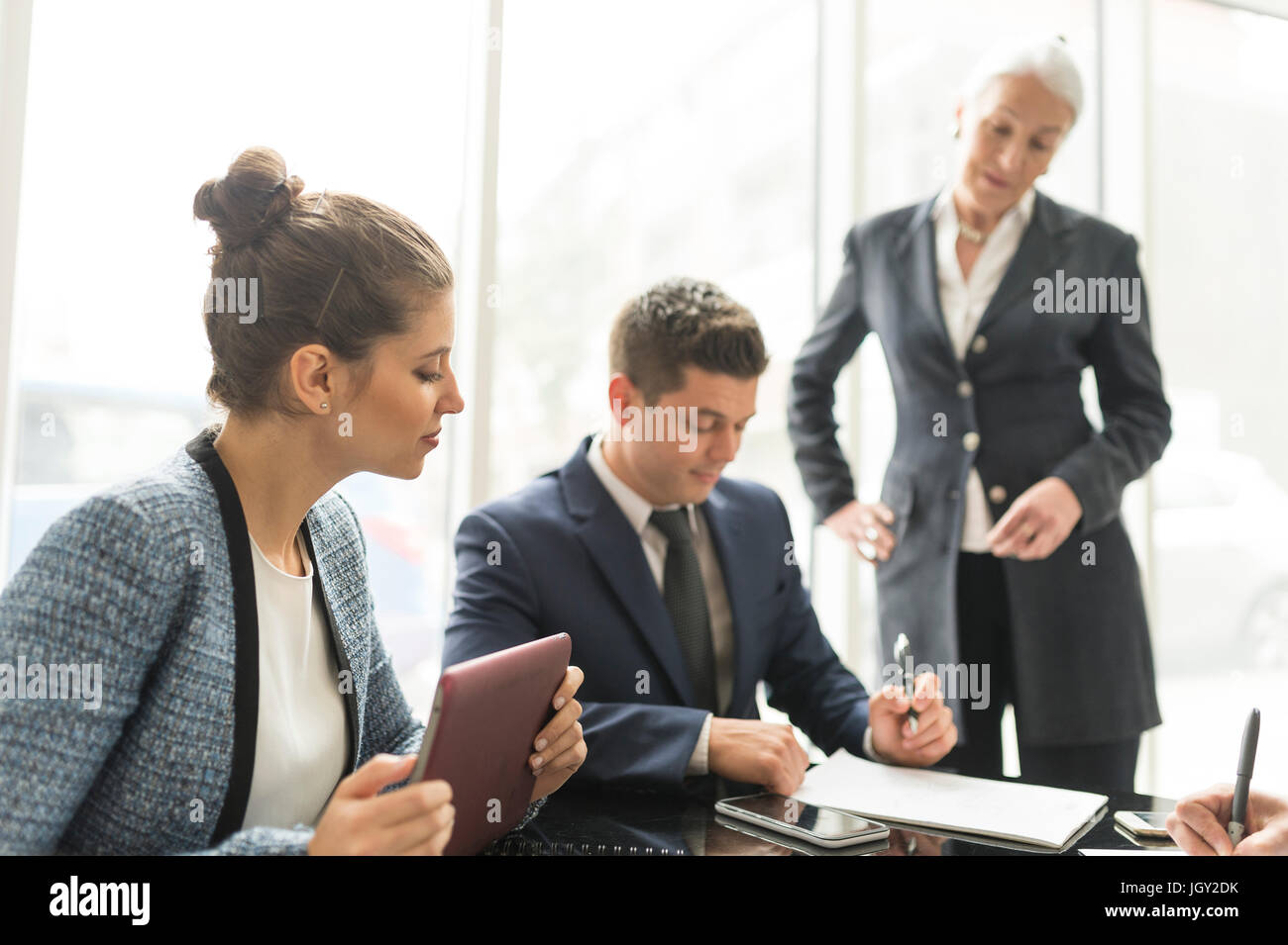 Empresario y mujeres haciendo notas en reuniones ejecutivas Foto de stock