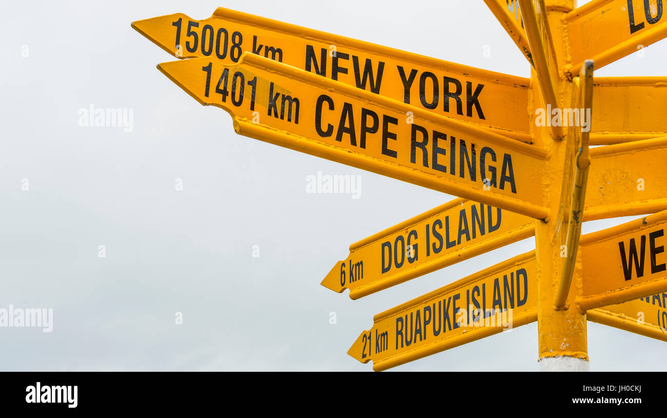 Las señales de color amarillo, señal con diferentes destinos, ciudades y distancias, Bluff, Isla del Sur, Nueva Zelanda Foto de stock