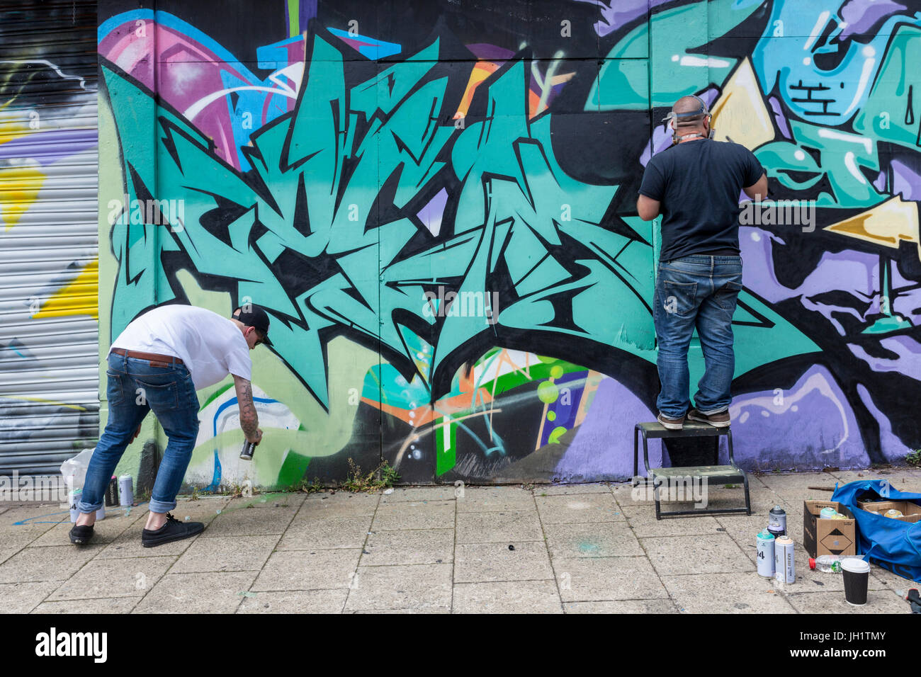 Los artistas del graffiti pintar una pared, Nottingham, Inglaterra, Reino Unido. Foto de stock