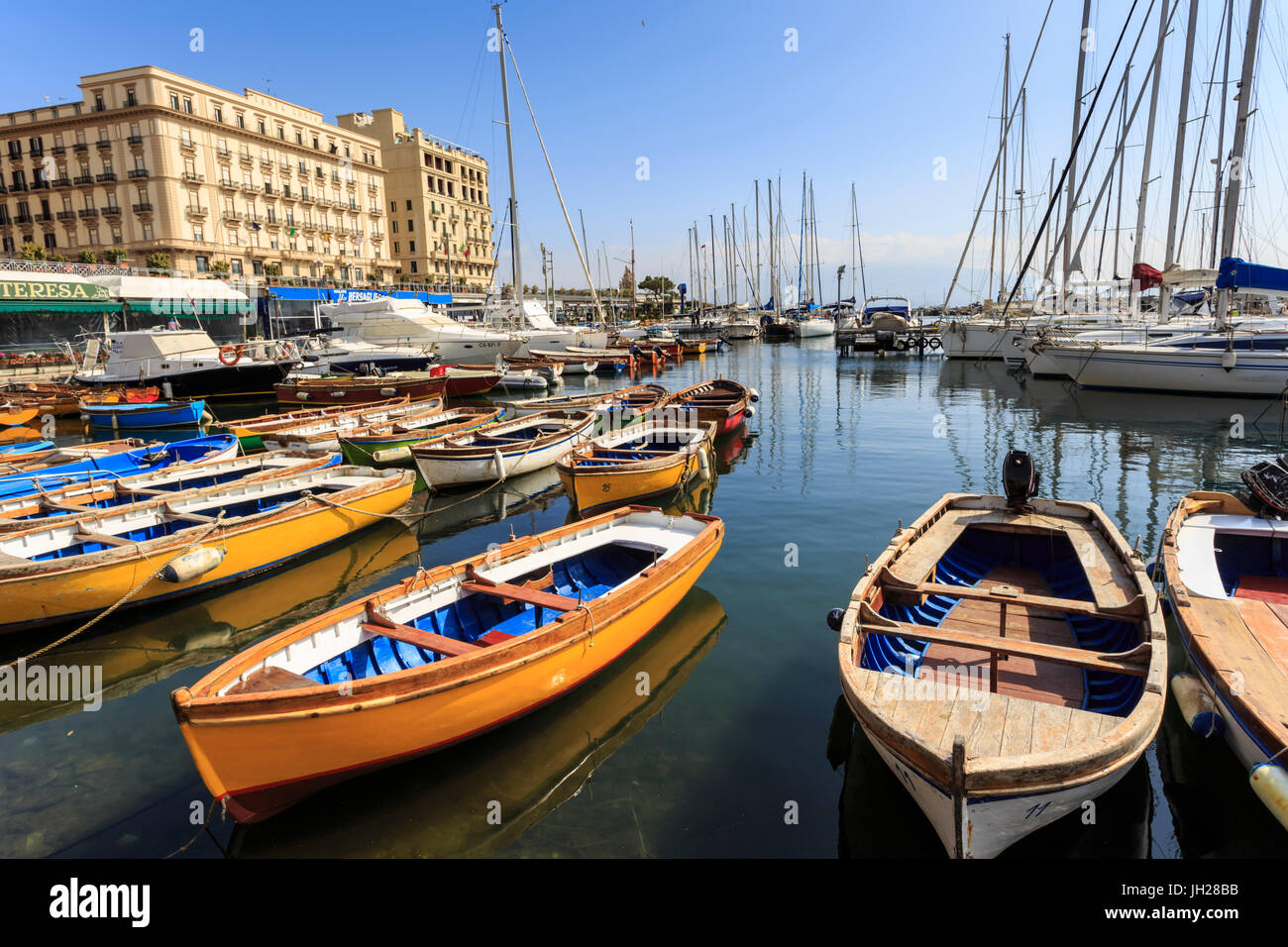 Yates y coloridas barcas de remo en la marina Borgo Marinaro, Vesubio en distancia, Chiaia, Ciudad de Nápoles, Campania, Italia Foto de stock