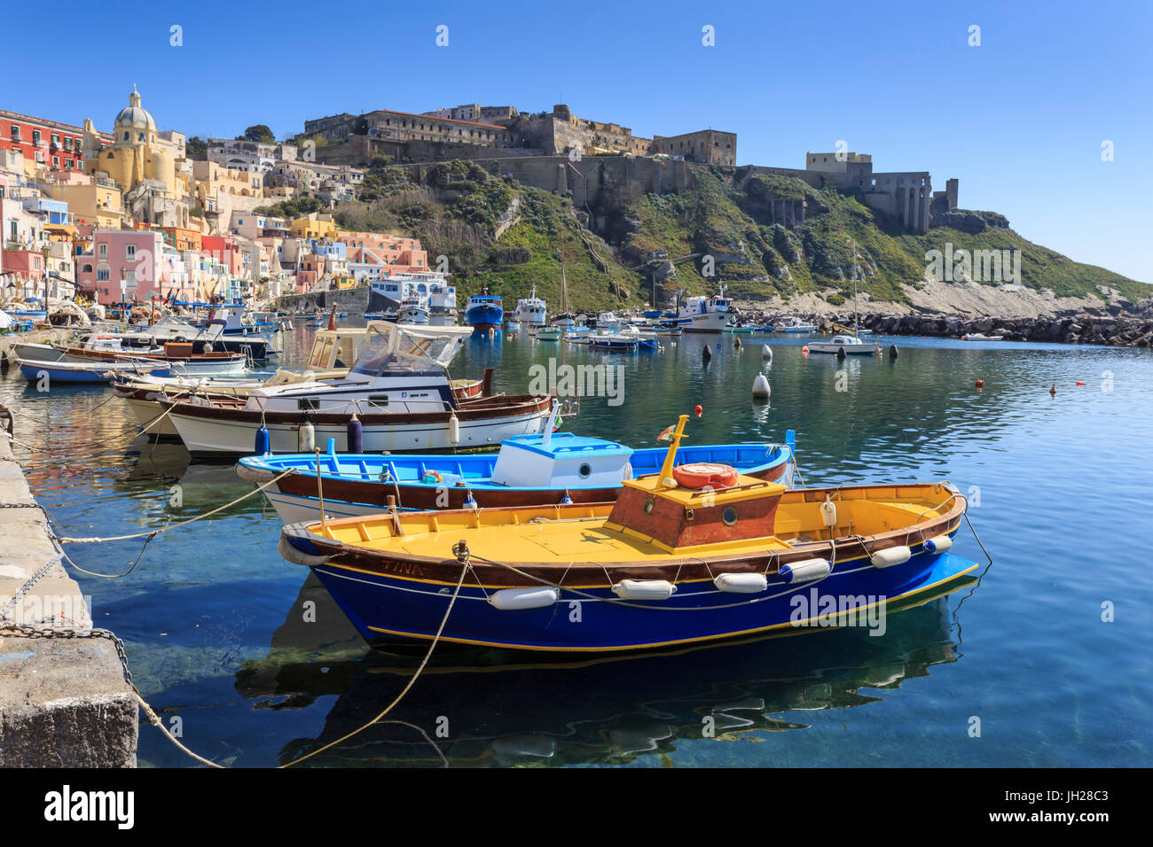 Marina Corricella, bonito pueblo pesquero y coloridas casas, barcos y Terra Murata, Procida Island, la Bahía de Nápoles, Italia Foto de stock