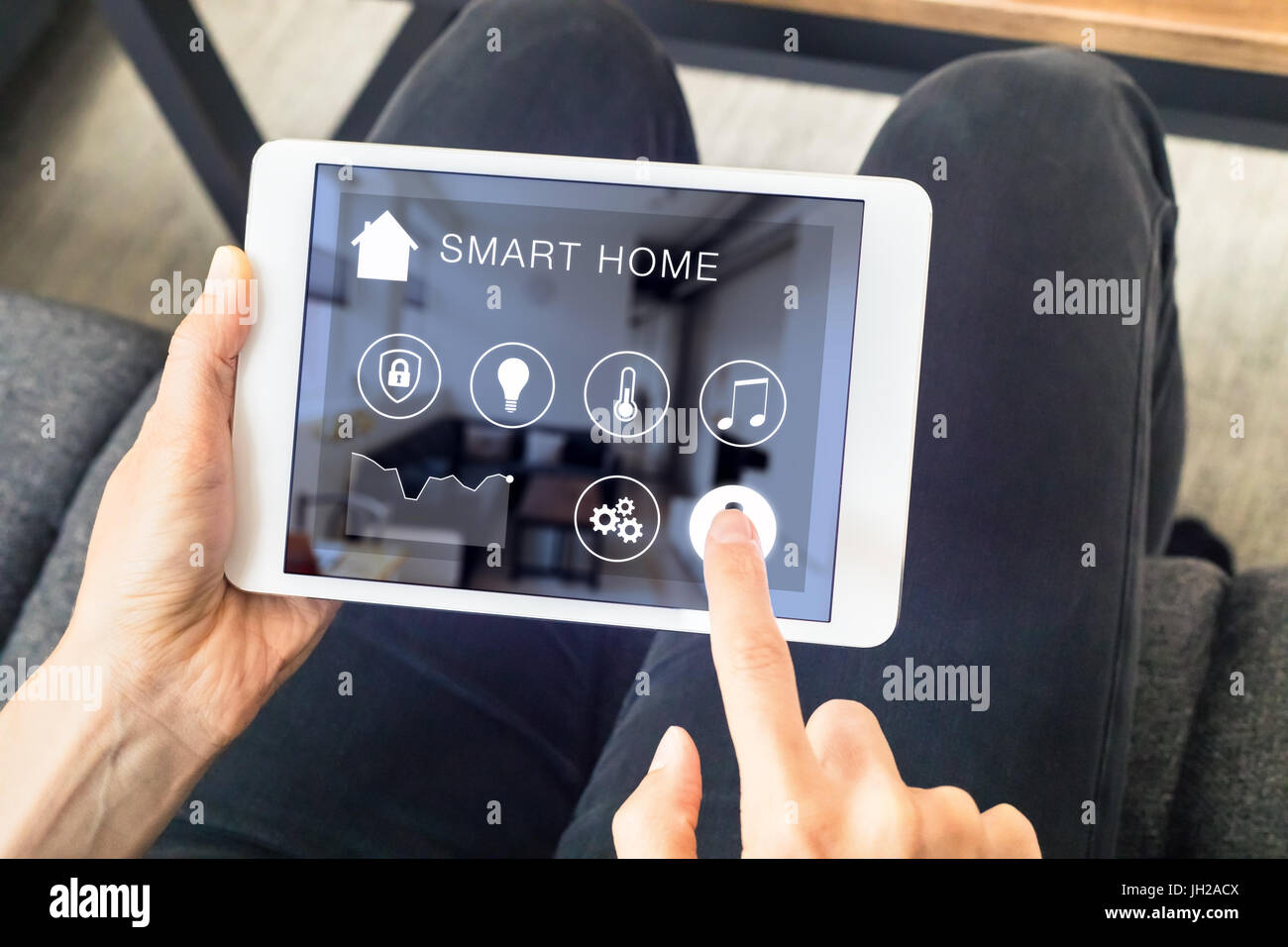 La persona utilizando la automatización inteligente en el hogar digital assistant en un equipo tablet PC para controlar los aparatos conectados en la habitación Foto de stock