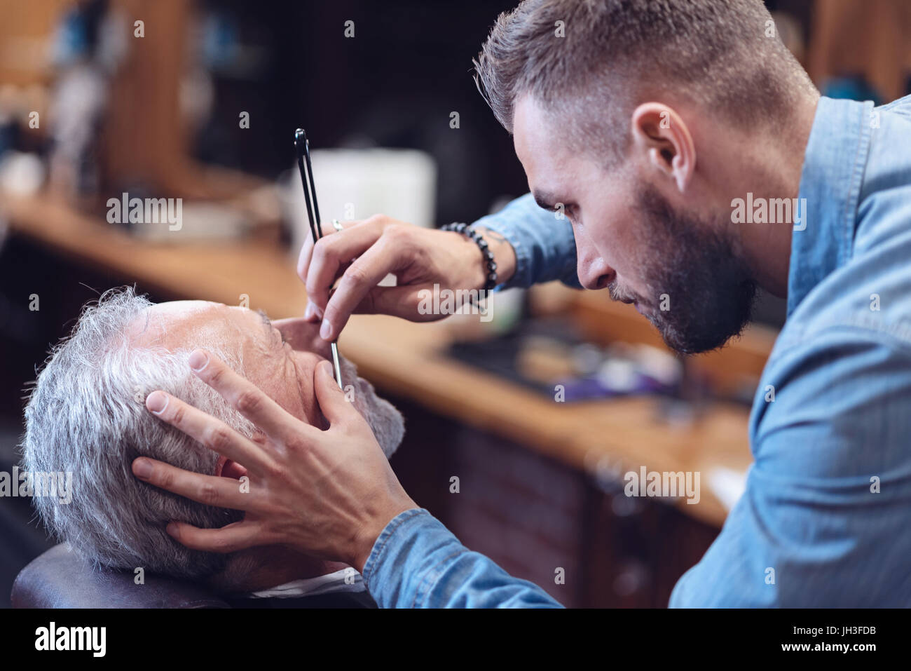 Seria agradable afeitado barber su cliente Foto de stock