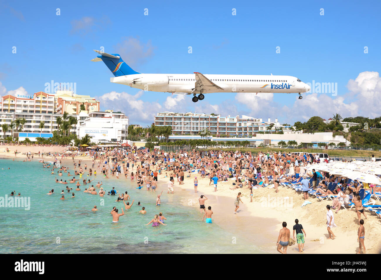 Gran avión vuela bajo sobre Maho Beach en St Maarten, Caribe, conocida como playa de avión Foto de stock