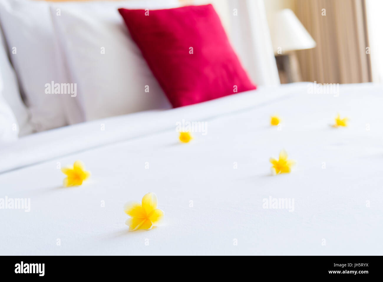 Habitación con cama y arreglo floral, copiar el espacio para texto Foto de stock