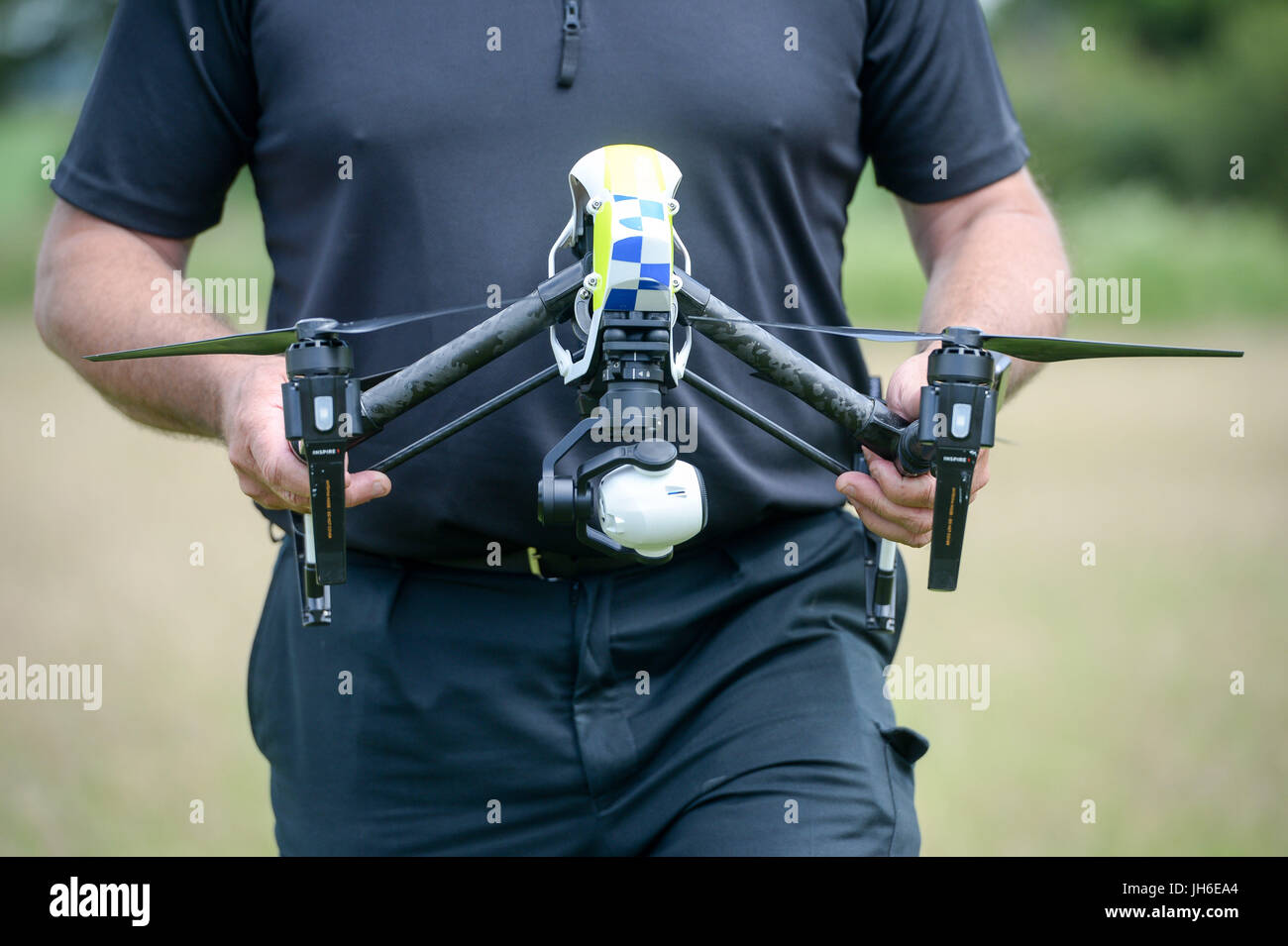 Embargado al 0001 Viernes 14 de julio un oficial de la policía de Devon & Cornwall lleva un drone del DJI Inspire 1s, mientras lanzan la primera unidad de drone totalmente operativa utilizada por la policía en Westpoint Arena en Clyst St Mary, cerca de Exeter, en cooperación con la policía de Dorset. Foto de stock