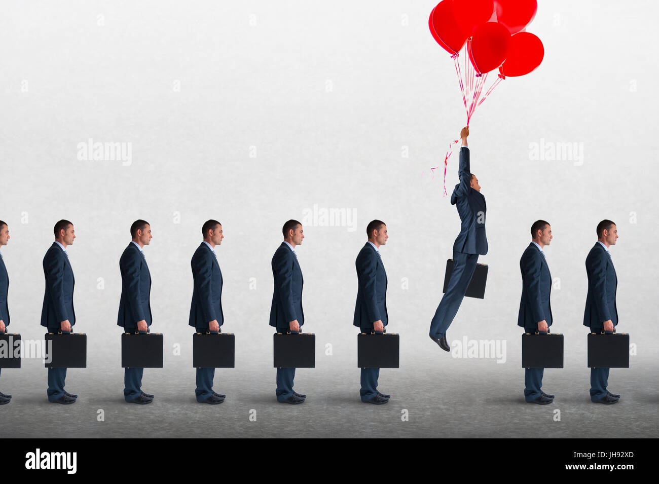 Concepto de negocio empresarial empresario levantándose sobre una cola de empresarios con globos de helio Foto de stock