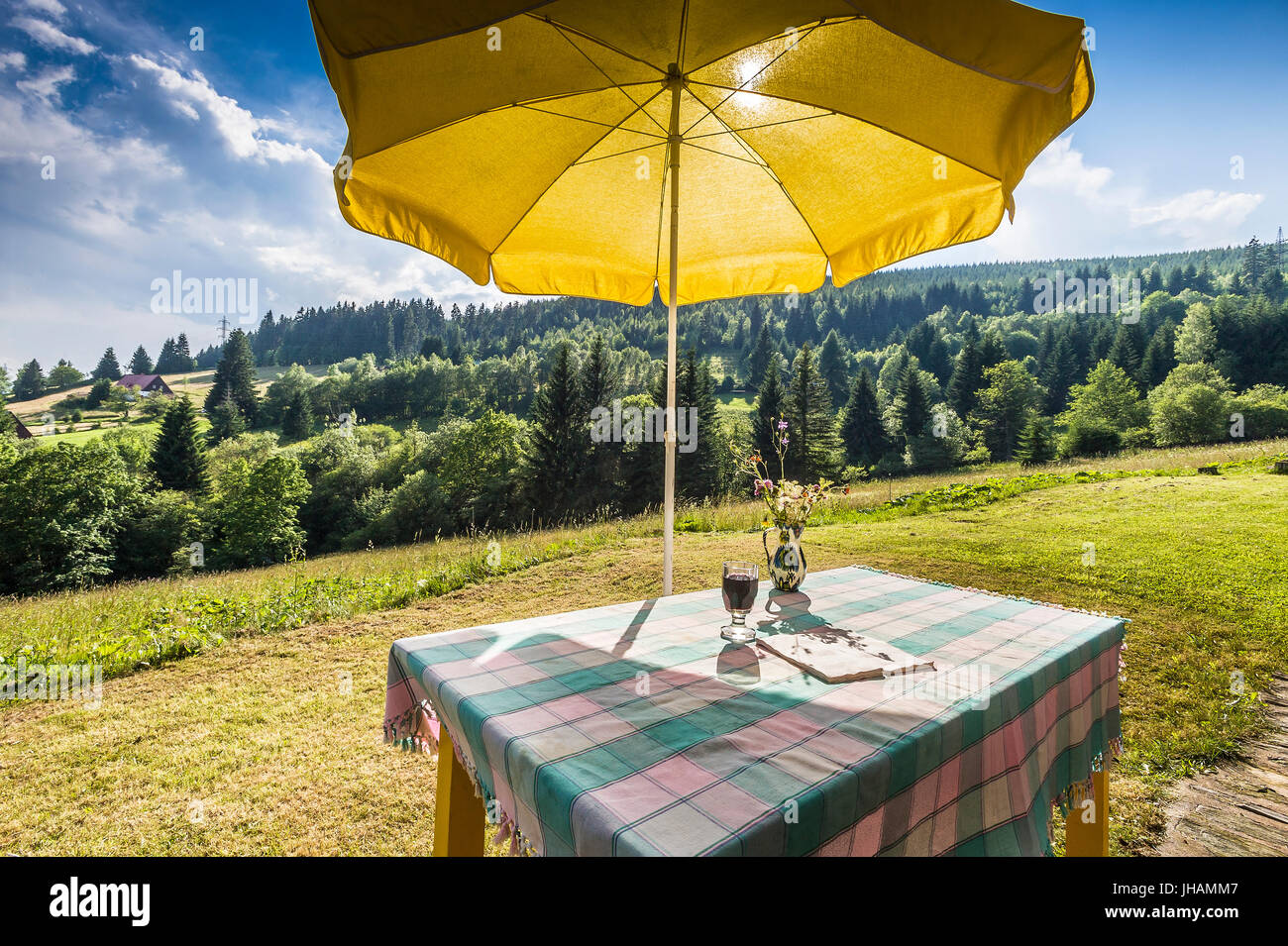 Mesa con mantel amarillo y sombrilla en montaña verano campaña Fotografía  de stock - Alamy