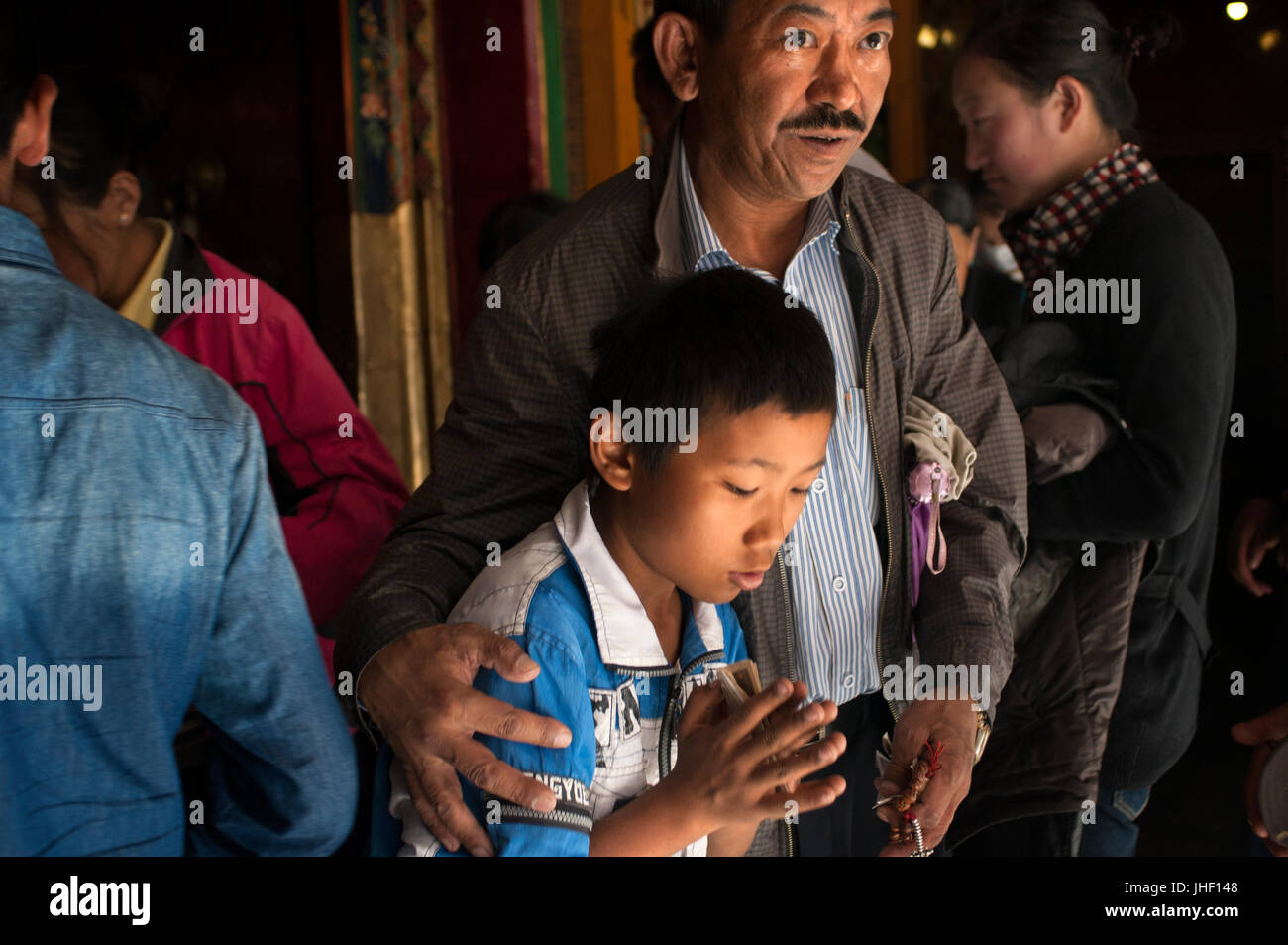Un hombre viejo con su hijo en el monasterio de Tsepak Lhakhang, Lhasa (Tíbet). Foto de stock