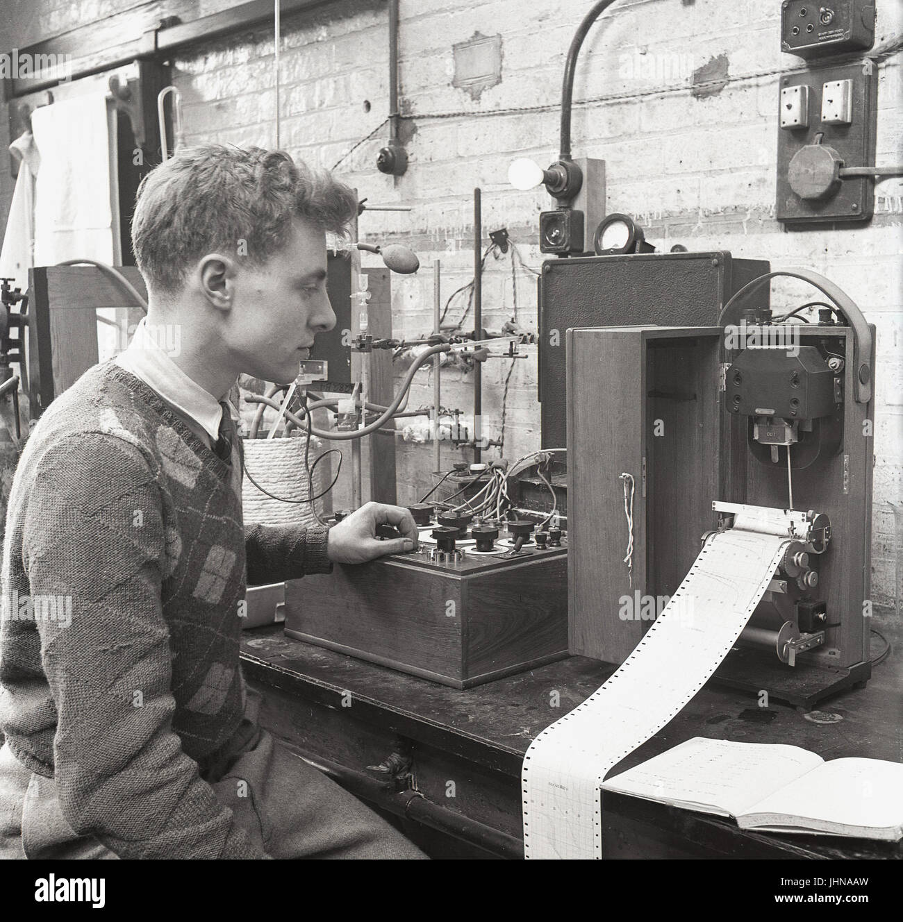 1950s, históricos, un estudiante de sexo masculino en un taller de laboratorio haciendo análisis químico con un instrumento polarograph, Universidad de Oxford, Oxford, Inglaterra, Reino Unido. Foto de stock