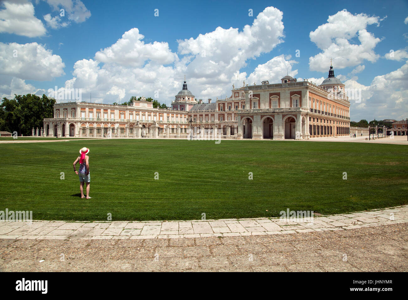 Mujer mirando al Palacio Real de Aranjuez, que es la primavera de la residencia de la Familia Real Española, ubicado sobre el río Tajo. Foto de stock