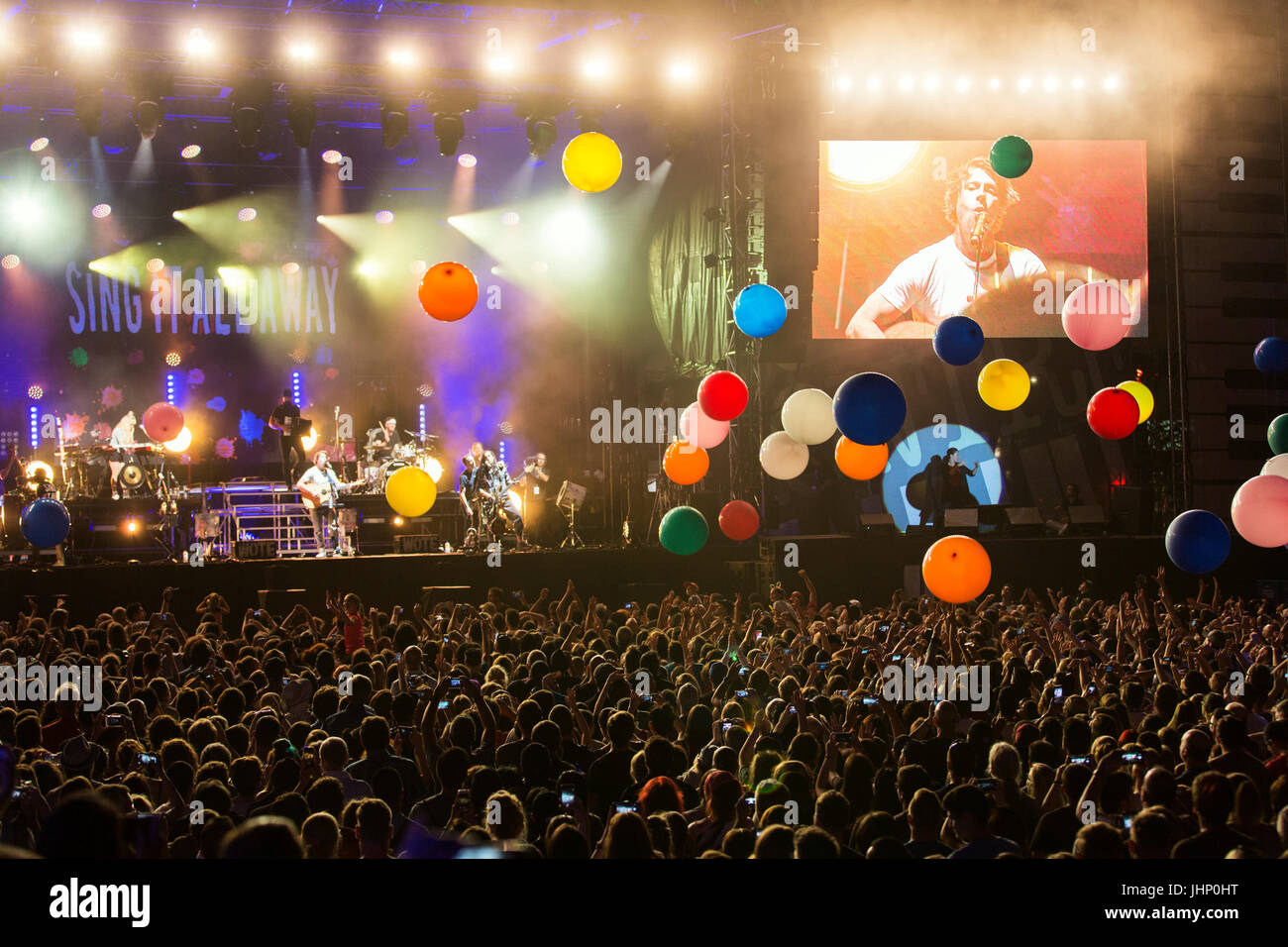 Festival de Jazz de Montreal, concierto al aire libre por la noche con multitudes de personas y músicos en el escenario, globos flotando en el aire por encima de la multitud Foto de stock