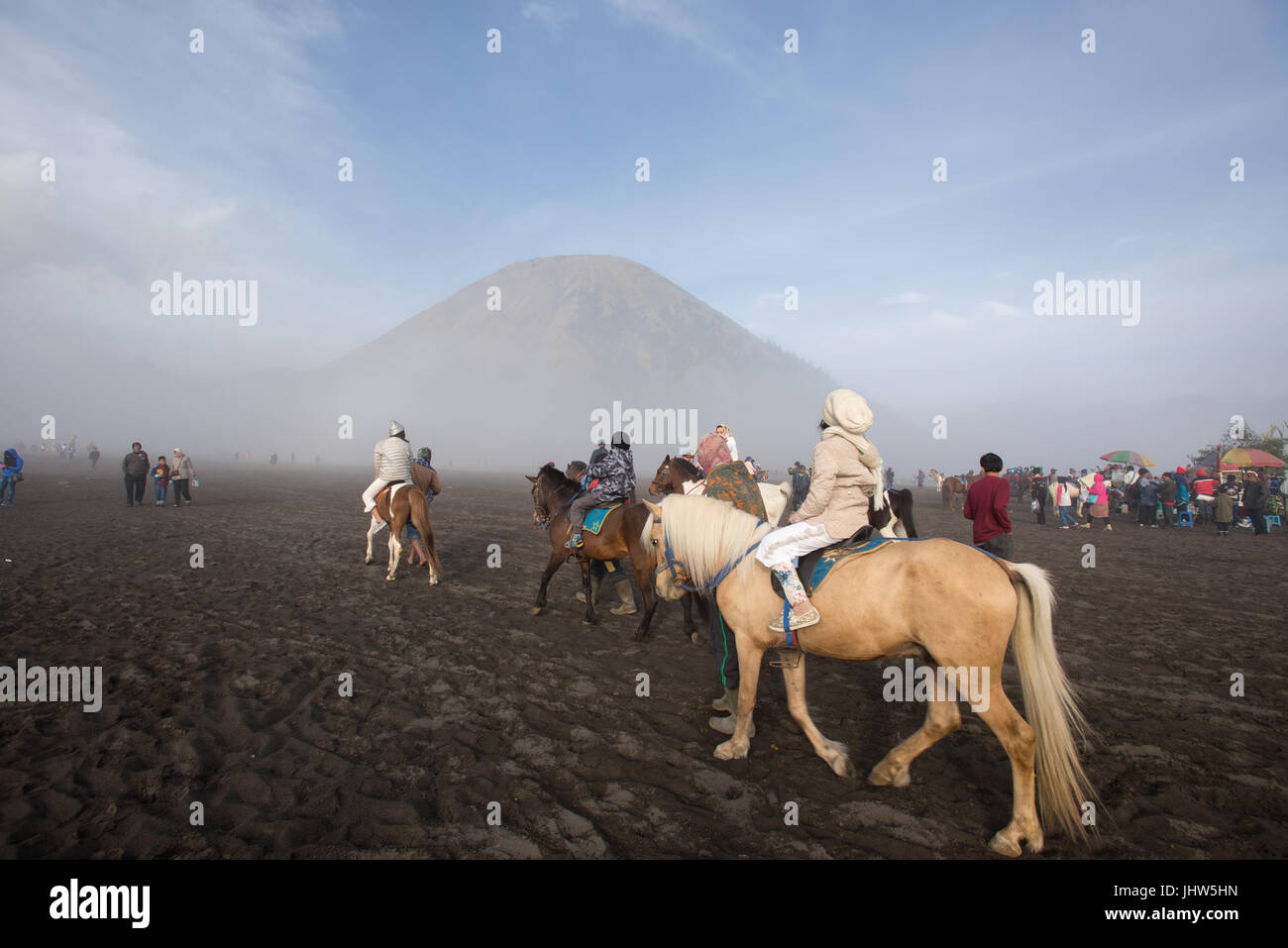 Los indonesios montar a caballo en el mar de arena en el Monte Bromo en Java Oriental de Indonesia. Foto de stock