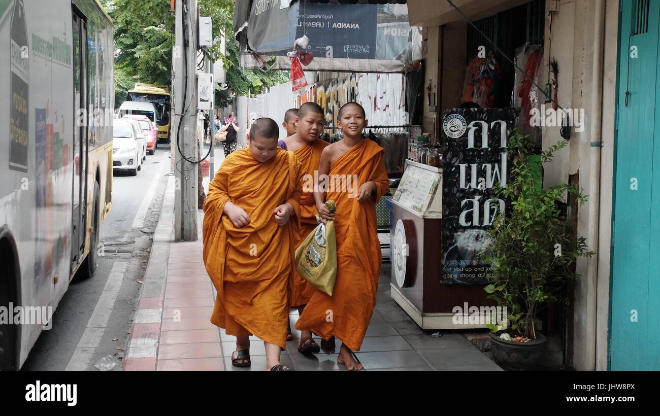 El monaquismo joven túnica de color naranja Azafrán Escuela Budista Theravada Wat Yannawa Boy monjes caminando por la calle Sathorn Bangkok Thailand Foto de stock