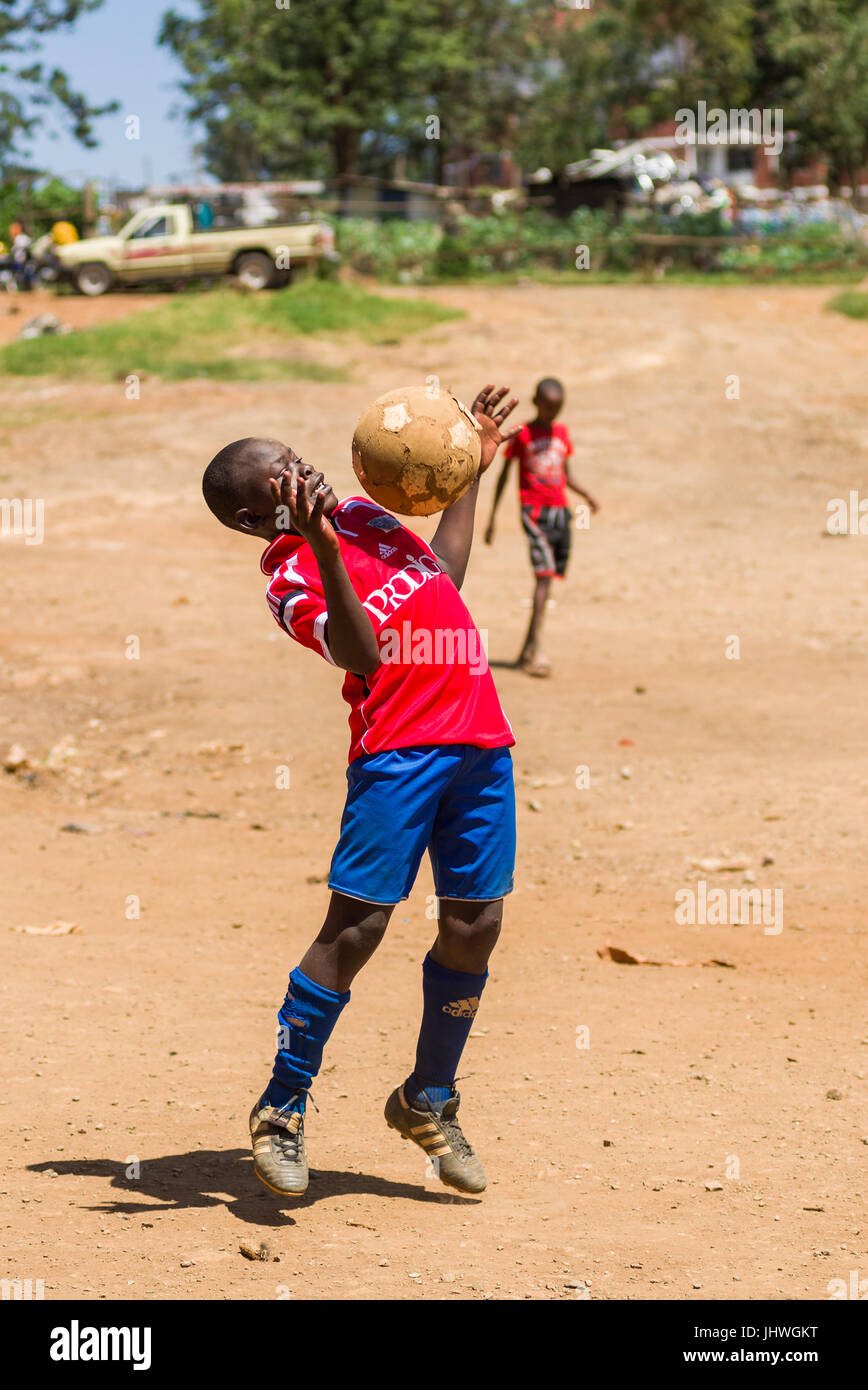 Los Ninos Del Barrio Pobre De Kibera Jugando Al Futbol En Un Tono Polvoriento Nairobi Kenia Fotografia De Stock Alamy