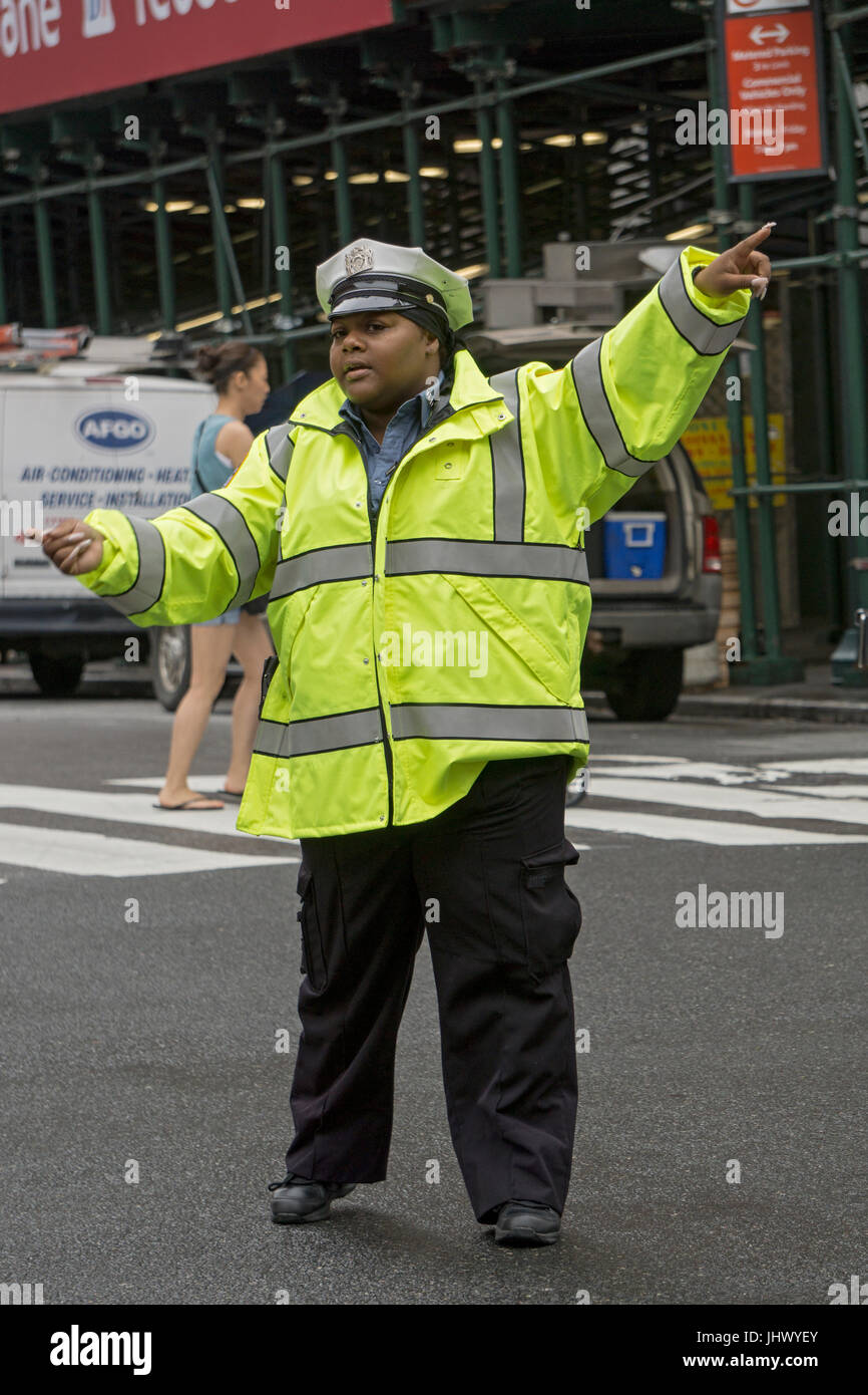 Mujeres de la ciudad de Nueva York dirigiendo el oficial de cumplimiento de tráfico de vehículos en East 34th Street y Park Avenue, en la Ciudad de Nueva York. Foto de stock