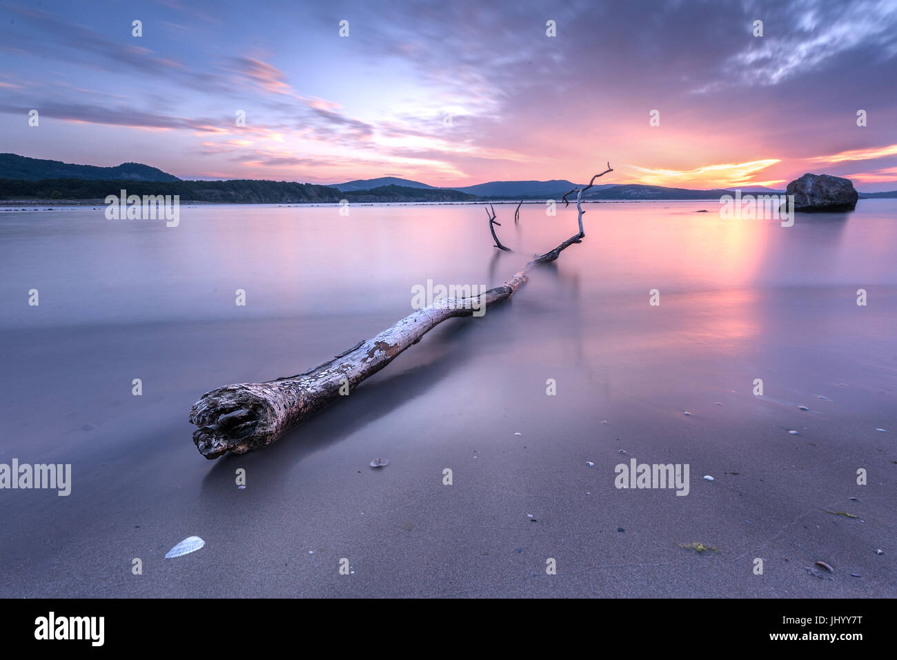 Magnífico mar púrpura del atardecer con casco de madera recortadas Foto de stock