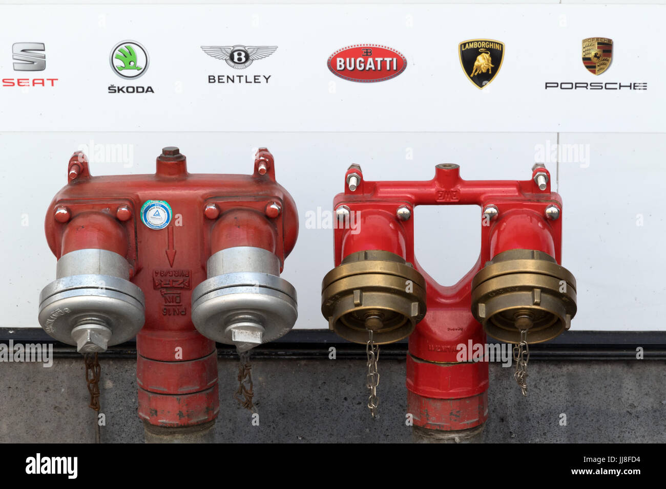 Los hidrantes de agua con logotipos de fabricantes de automóviles en la pared de fondo Foto de stock