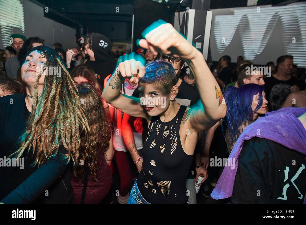 BRISTOL, REINO UNIDO - Noviembre de 2016: Una joven mujer atractiva con tatuajes y el pelo corto, hace puñetazos en la cámara como baila en un club nocturno en noviembre Foto de stock