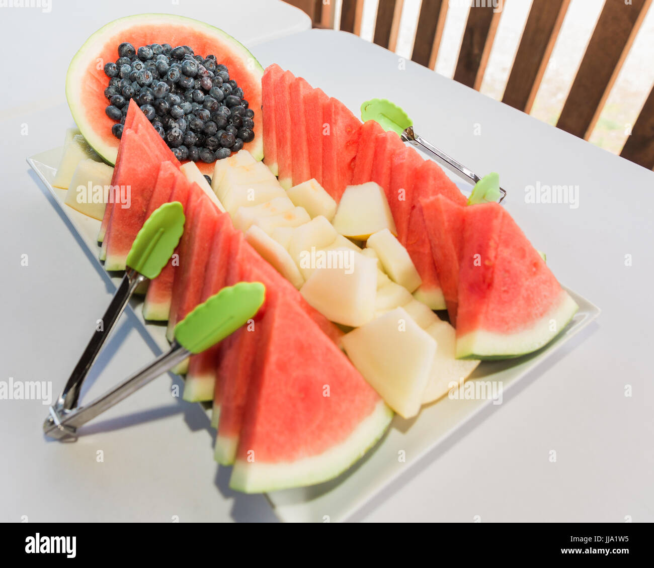 Plato de frutas frescas ideas de diseño para el banquete o el desayuno. Rodajas de melones y bayas en bandejas listo para ser comido. Foto de stock