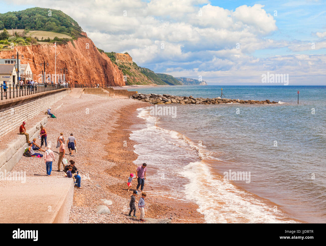 El 3 de julio de 2017: Sidmouth, Dorset, Inglaterra, Reino Unido - Los visitantes en la playa de guijarros en un brillante día de verano. Foto de stock