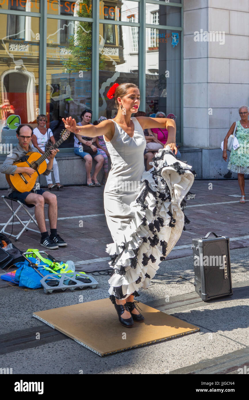 El Guitarrista y la bailaora de flamenco con el tradicional vestido blanco bailando como espectáculo de calle durante fiestas de verano Foto de stock