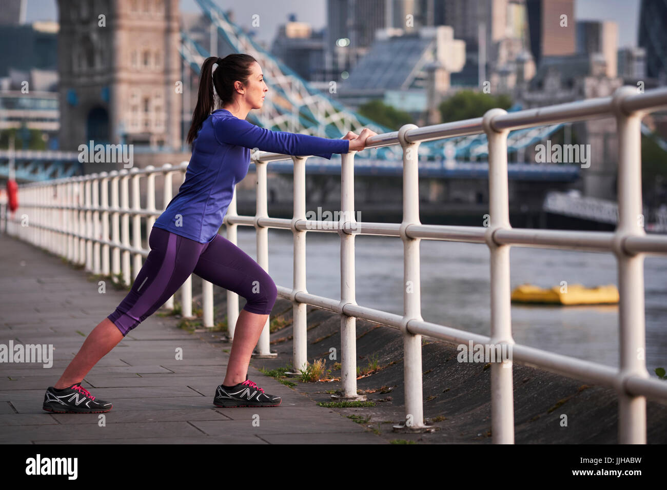 Una mujer descansando después de un recorrido junto al río Támesis en Londres. Foto de stock