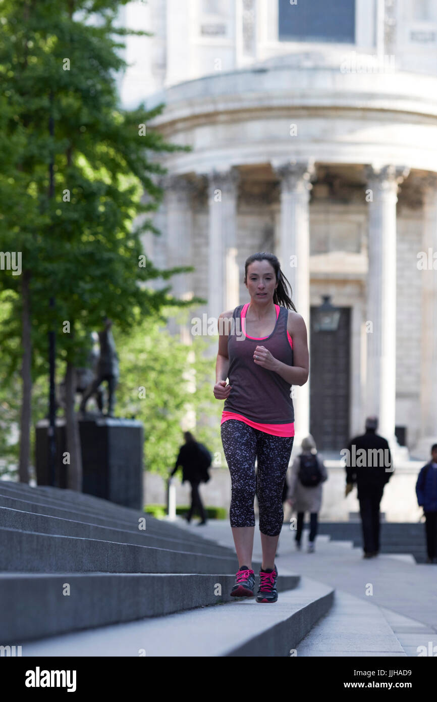 Una mujer corriendo en la zona de St Paul's de Londres. Foto de stock