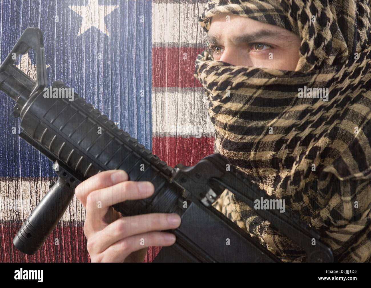 Soldado la celebración de arma de fuego contra la bandera americana Foto de stock