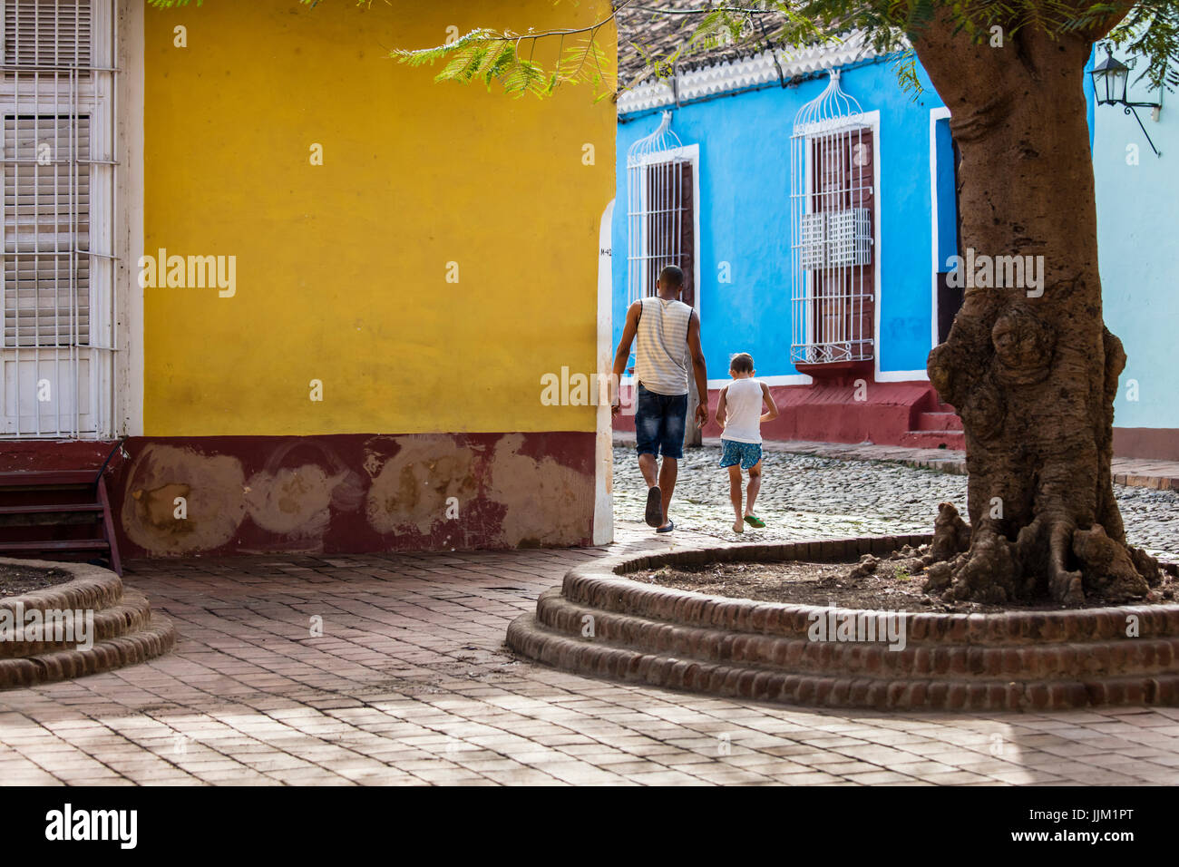 Un padre y su hijo caminando por calles adoquinadas gthe - TRINIDAD, CUBA Foto de stock