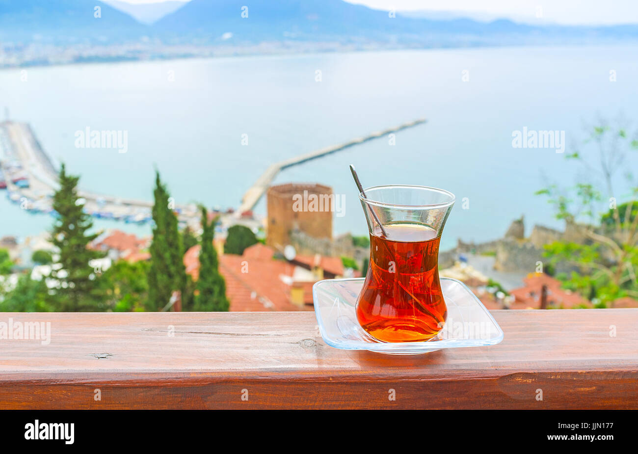 La taza de té negro con la Torre Roja y la antigua marina de Alanya en fondo, Turquía. Foto de stock