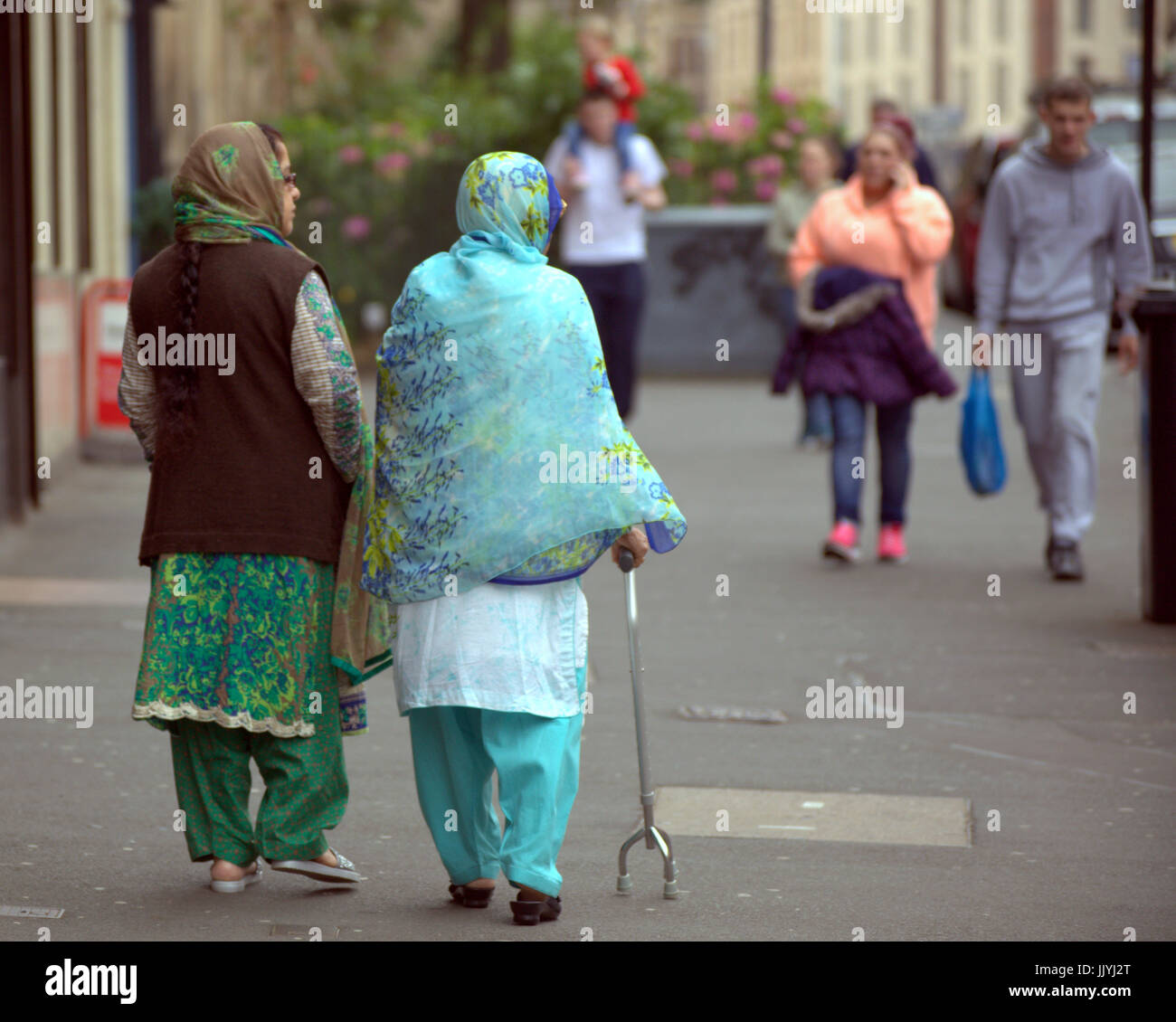 Refugiados asiáticos visten el Hijab pañuelo sobre calle escena cotidiana en el REINO UNIDO Foto de stock