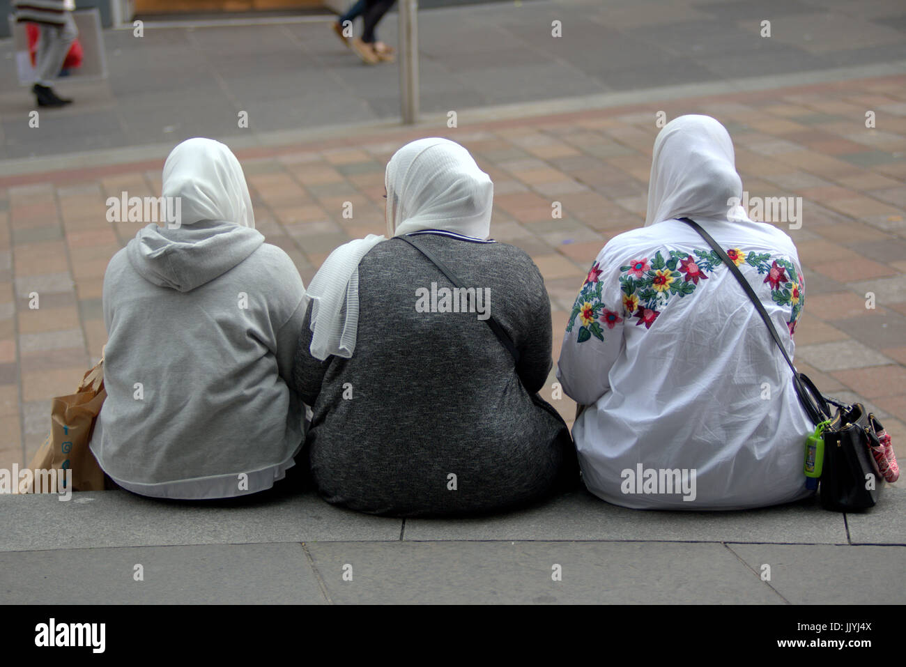 Refugiados asiáticos visten el Hijab pañuelo sobre calle escena cotidiana en el REINO UNIDO Foto de stock