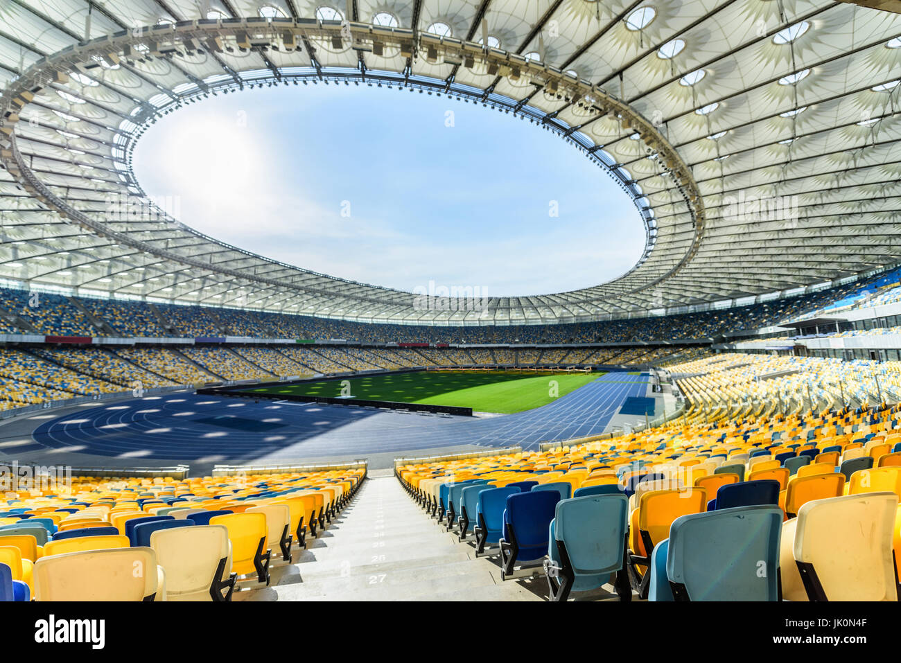 Filas de asientos del estadio amarillo y azul sobre soccer Field Stadium Foto de stock