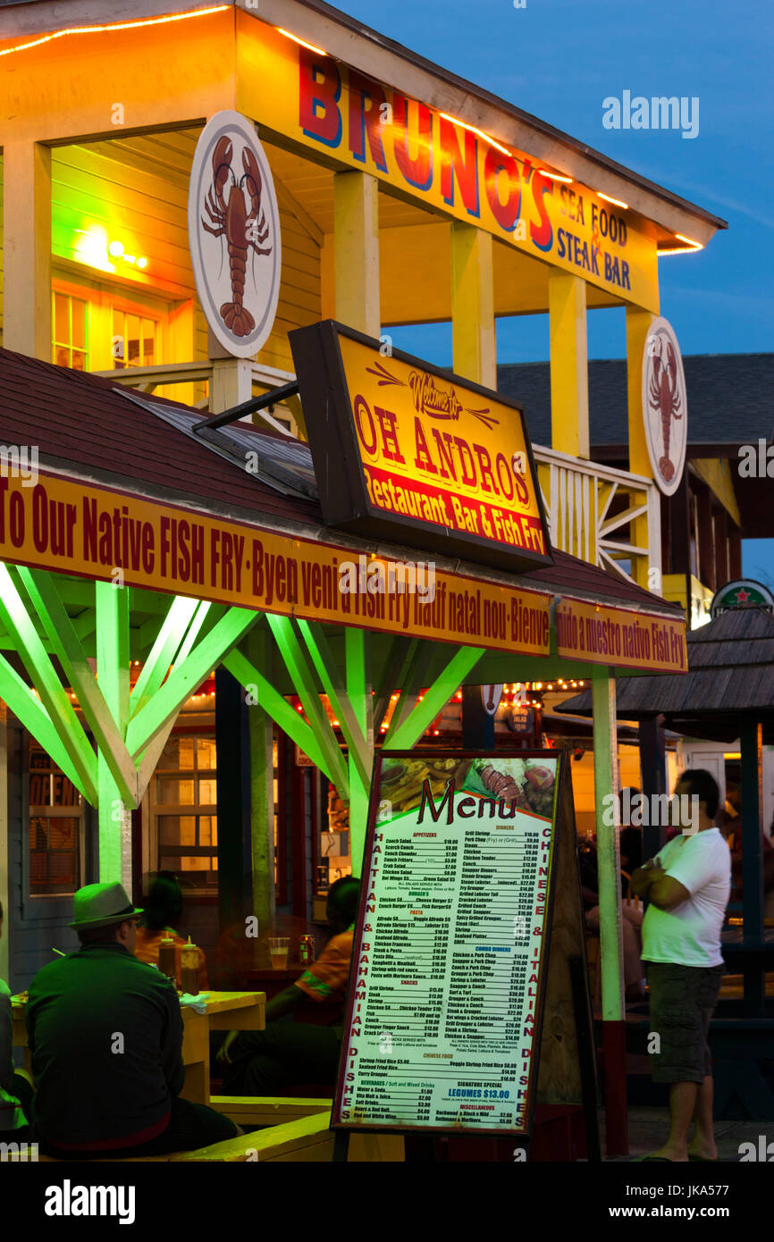 En la isla de Nueva Providencia, Bahamas, Nassau, Arawak Cay, restaurantes de pescado frito, signos, el anochecer Foto de stock