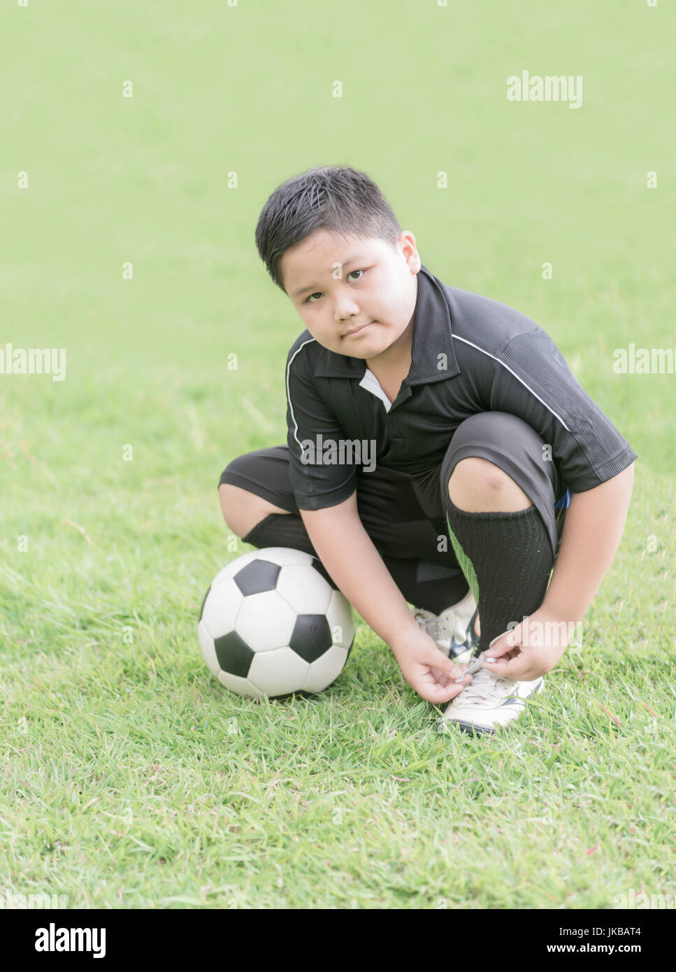 Niño obeso preparándose para el juego de fútbol atando sus zapatos,  concepto saludable Fotografía de stock - Alamy