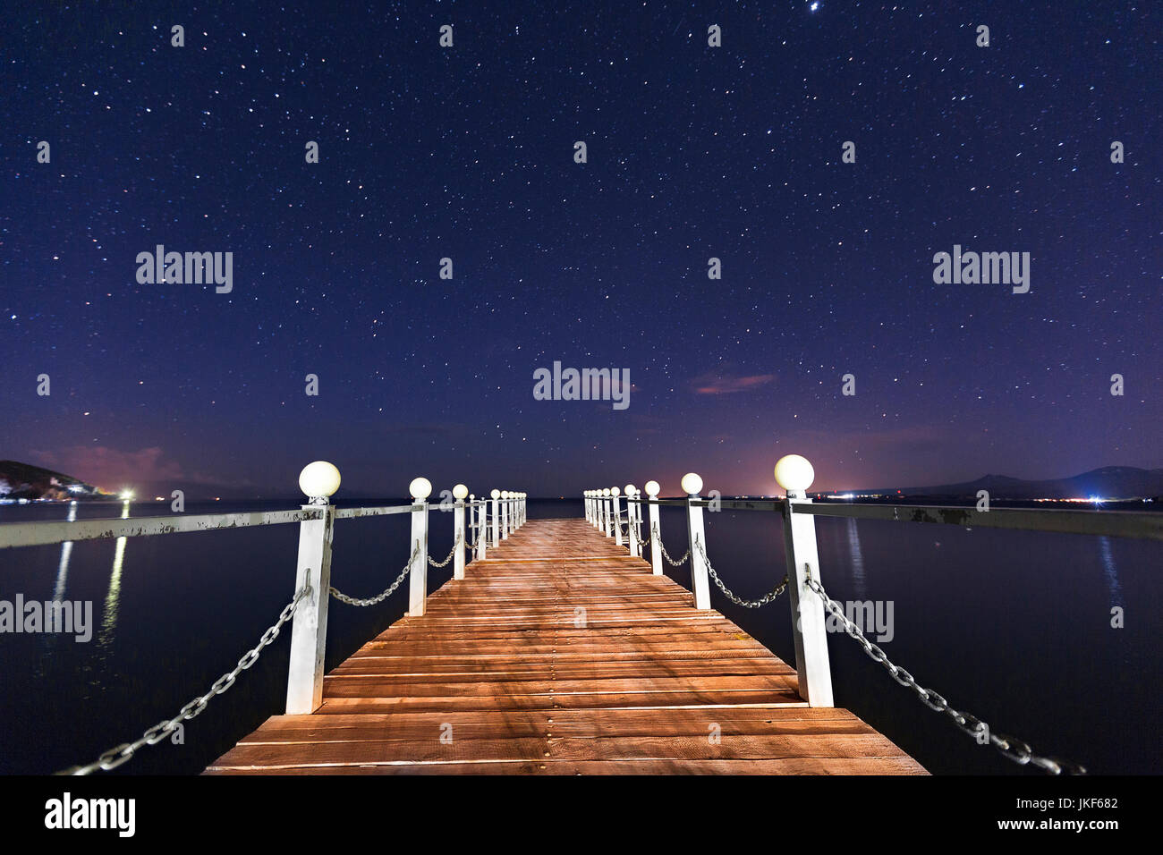 Muelle de madera en el lago Sevan, con las estrellas en el cielo, Armenia. Foto de stock