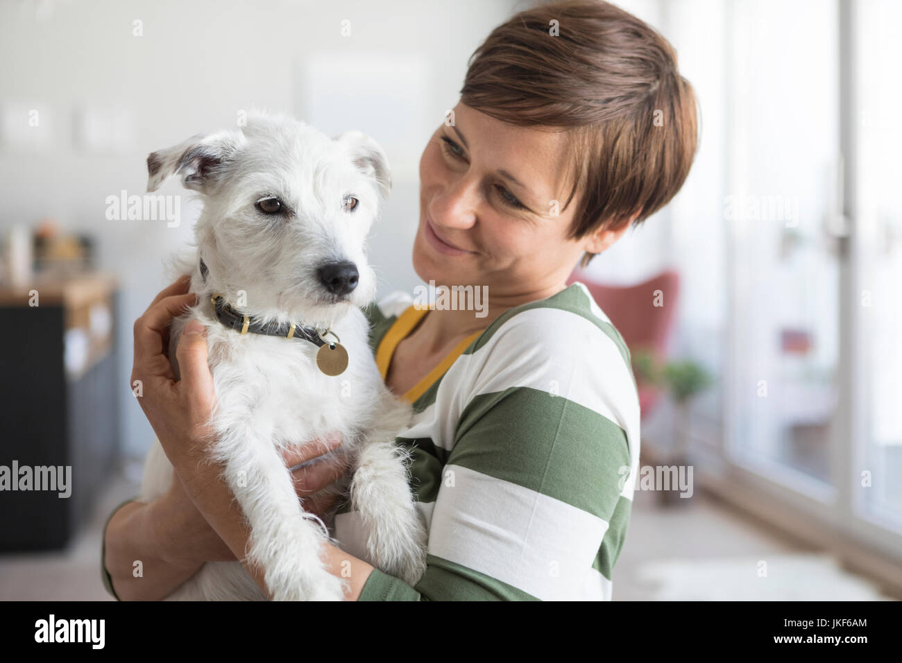 Mujer con su perro en casa Foto de stock