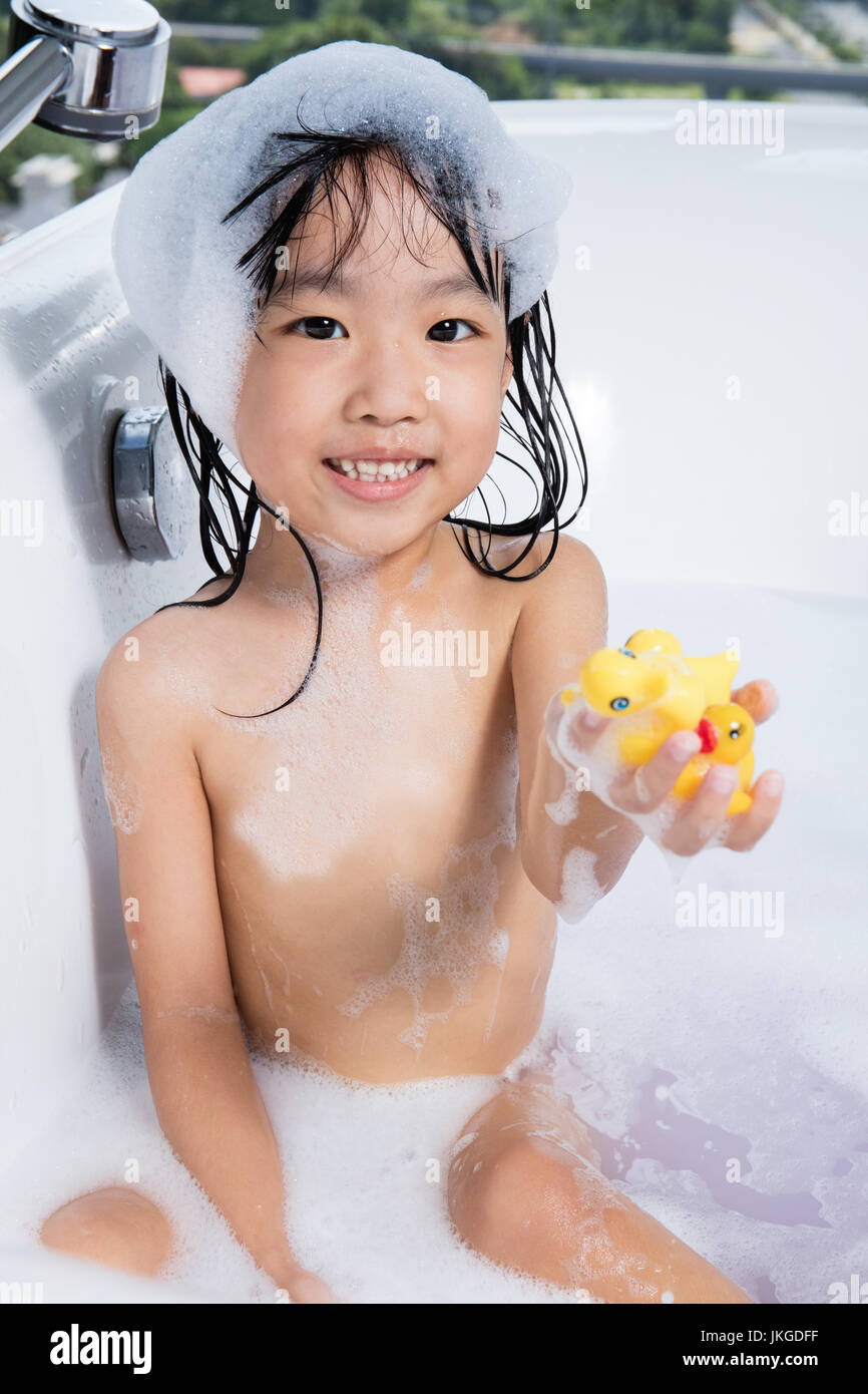 Niña China Asia jugando con agua y espuma en la bañera en casa Fotografía  de stock - Alamy