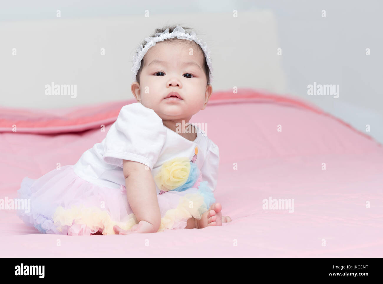 Bonita niña bebé sentarse en Manta rosa Foto de stock