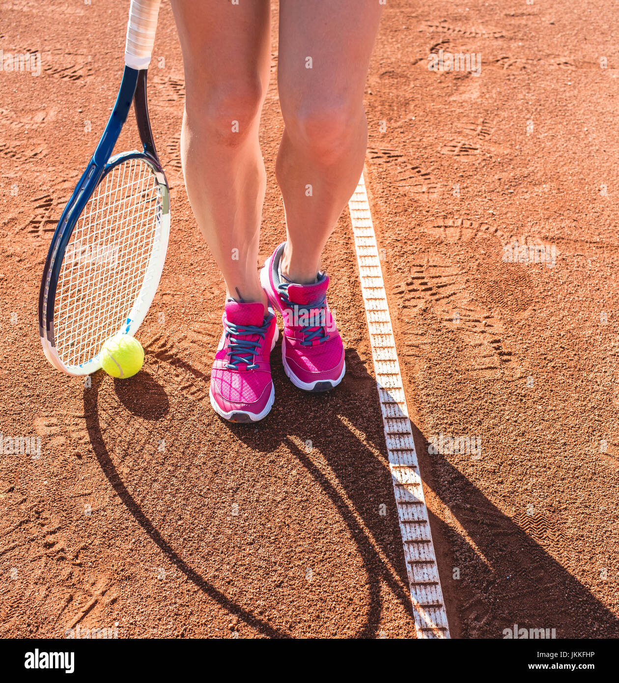 Piernas femeninas con raqueta de tenis Foto de stock