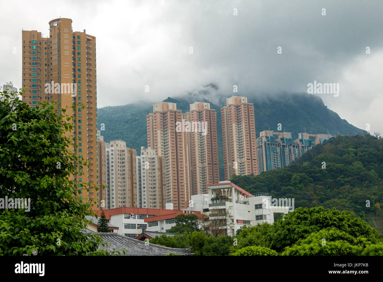China. Un día nublado en Hong Kong. Rascacielos residencial contra el telón de fondo de montañas boscosas y nubes bajas Foto de stock