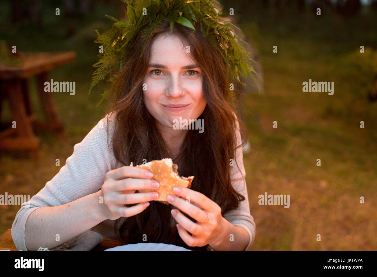 Encantado mujer comer una hamburguesa Foto de stock