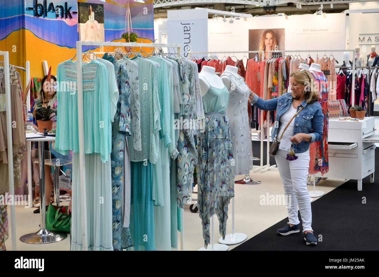 Comprador de Moda explora la ropa está en el Pure London, Olympia, Londres,  Reino Unido. Pure de Londres, los líderes del Reino Unido comercio  exposición moda abrió sus puertas 23-25º de julio