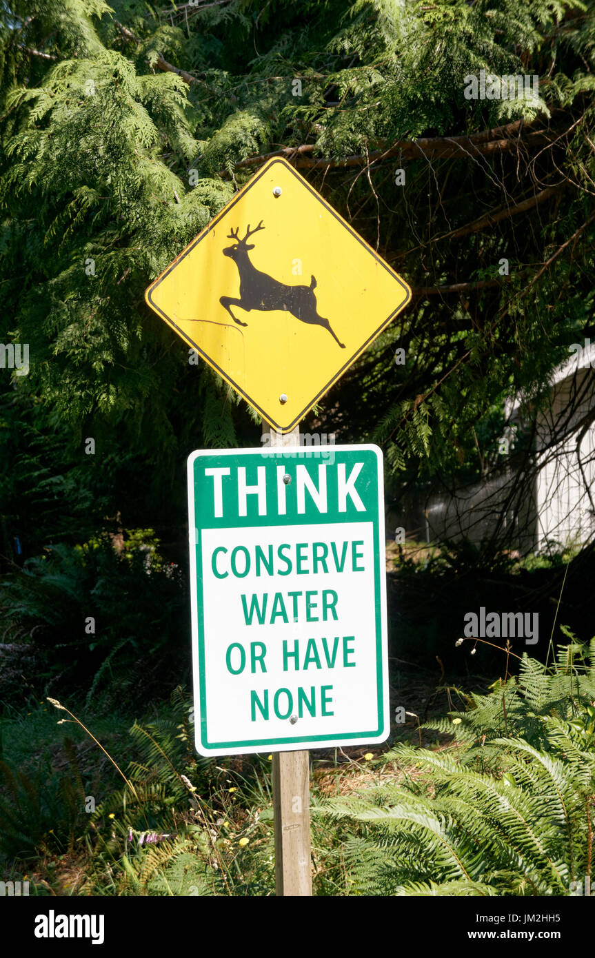 Deer crossing road sign signo y conservar el agua en la isla de Bowen cerca de Vancouver, British Columbia, Canadá Foto de stock