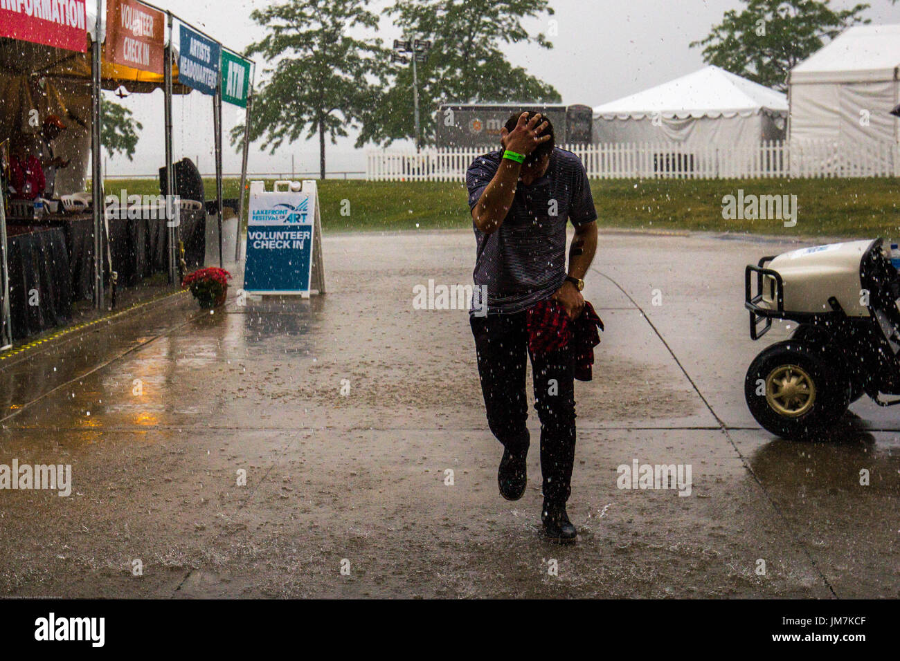 En ejecución de la lluvia con su mano sobre su cabeza. Foto de stock