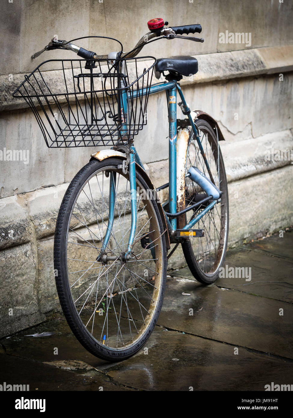 Estudiante de bicicletas - un estudiante bike se inclina contra una pared central college en Cambridge, Reino Unido Foto de stock