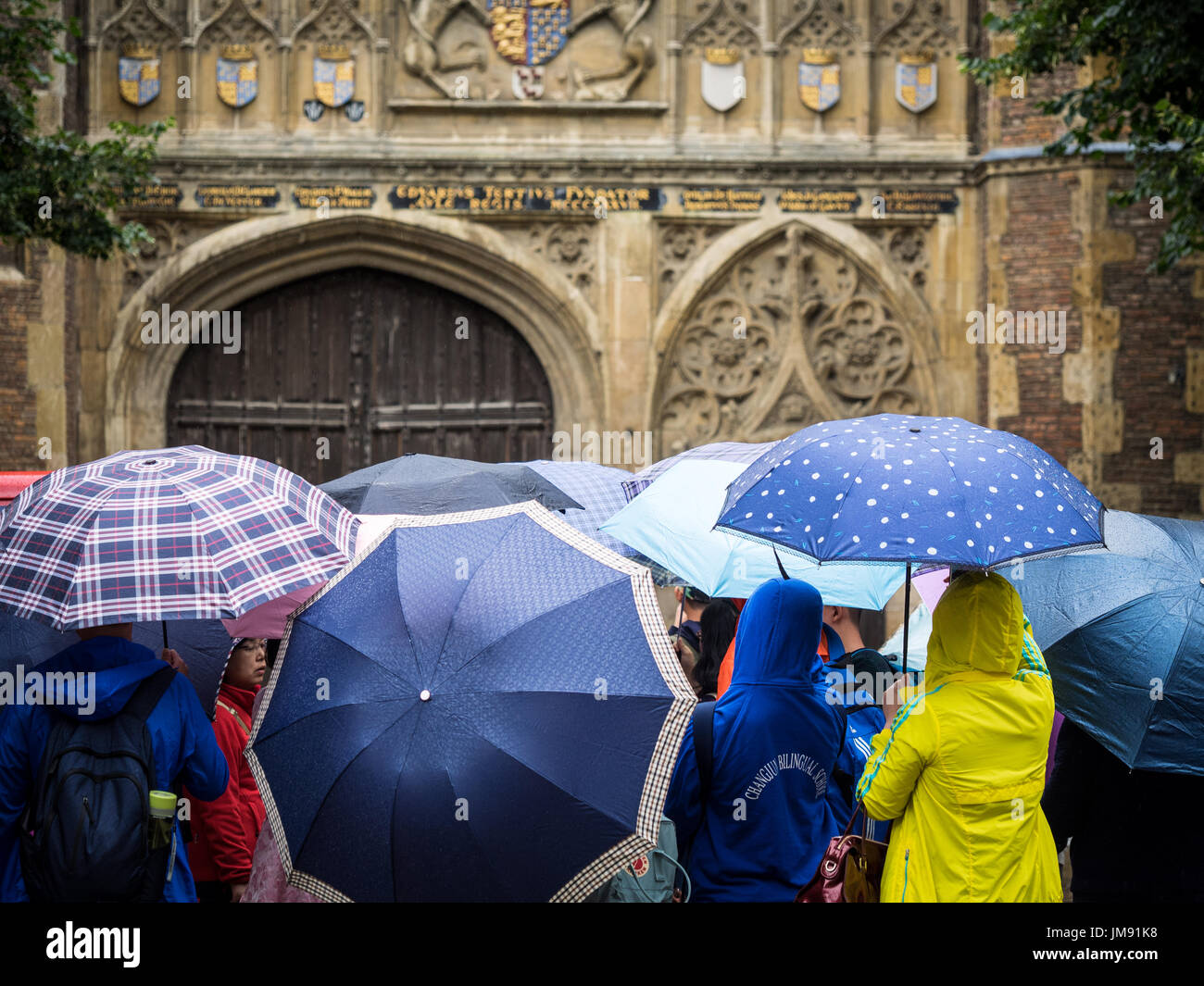 Los turistas en Cambridge - a los turistas ver el Trinity College, parte de la Universidad de Cambridge, en un día lluvioso Foto de stock