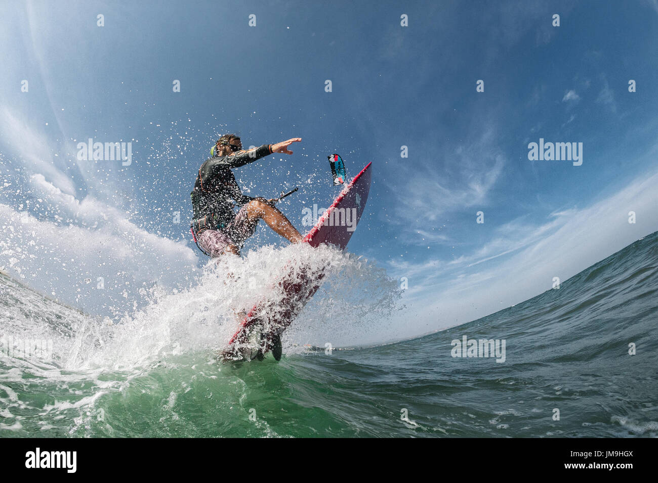 Kite surfer cabalga las olas Foto de stock